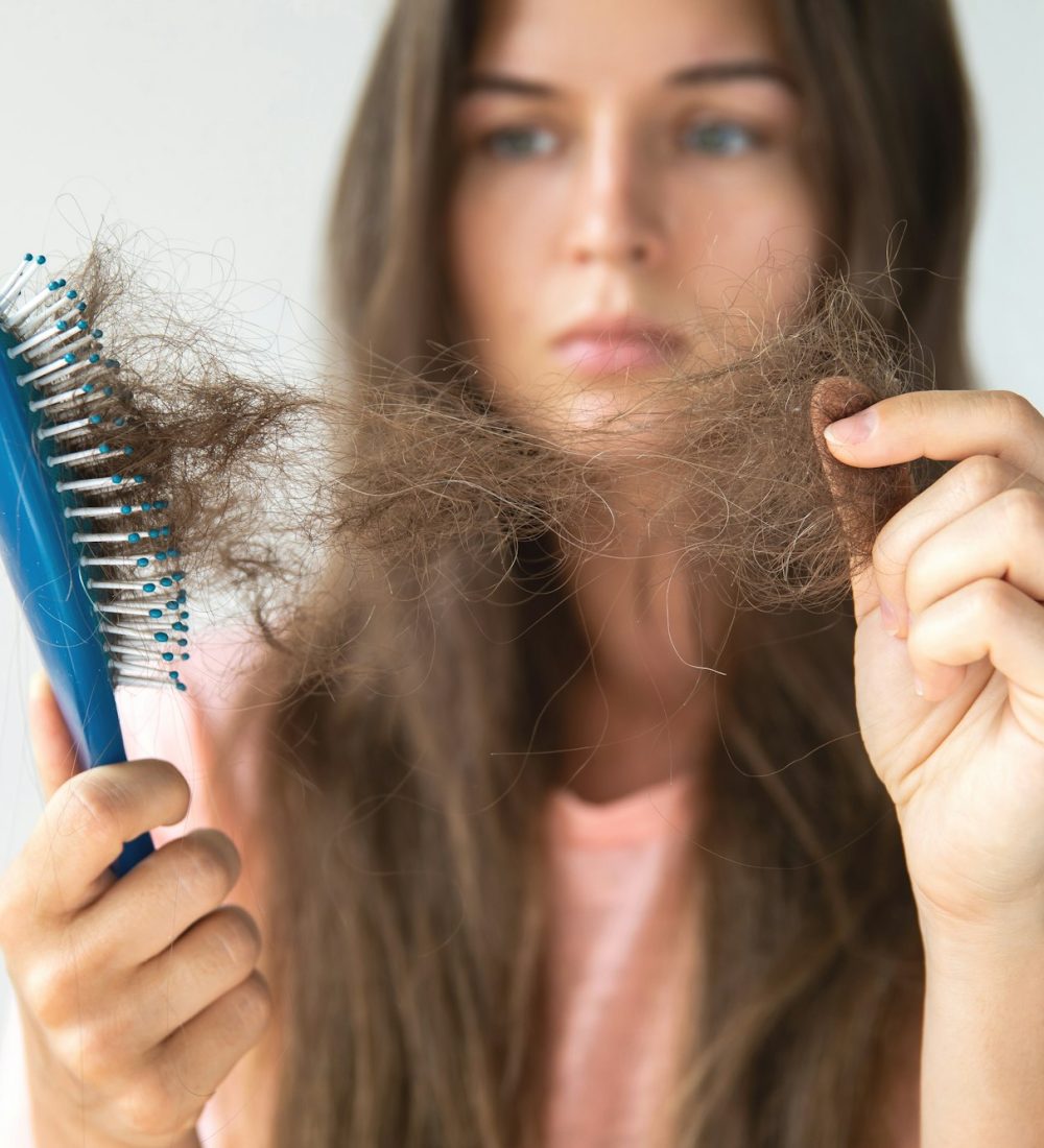 Young woman is upset because of hair loss